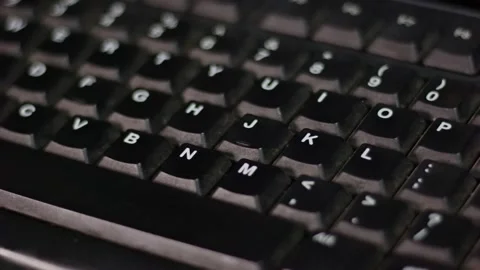 Black Computer Keyboard Keys Illuminated By Shifting Light Creating Moving .. Stock Footage 338225043