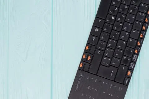 Black computer keyboard on light blue background. Stock Photos