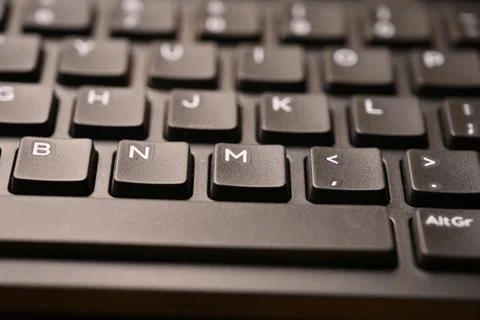 Black Computer Keyboard Macro Shot Highlighting M Key with Soft Blurred Bac.. Stock-Fotos