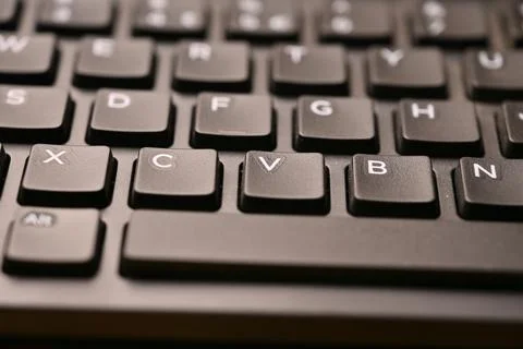 Black Computer Keyboard Macro Shot Highlighting V Key with Soft Blurred Bac.. Stock Photos