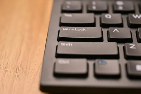 Black Computer Keyboard Macro Shot Highlighting Caps Lock Key with Soft Blu.. 스톡 사진