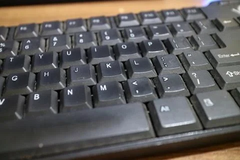 A black computer keyboard, slightly dusty Stock Photos
