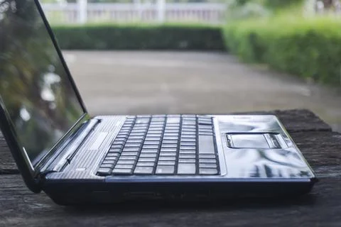 Black computer laptop or notebook empty on a wood table with a black screen.. Stock Photos