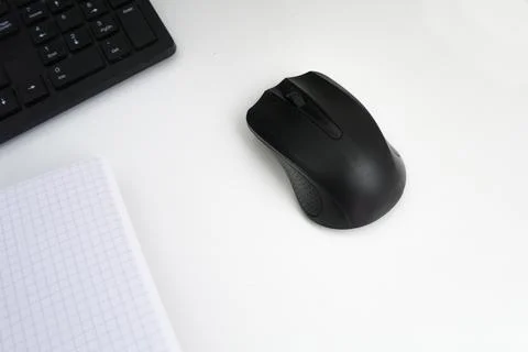 Black computer mouse on a white table, close up Stock Photos