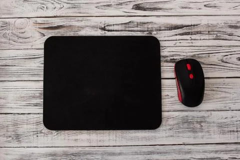 Black computer mousepad with a mouse on a white wooden background Fotos Stock