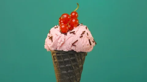 Black cone, waffle cup with berry ice cream decorated with red currant on green Stock Footage 108739508
