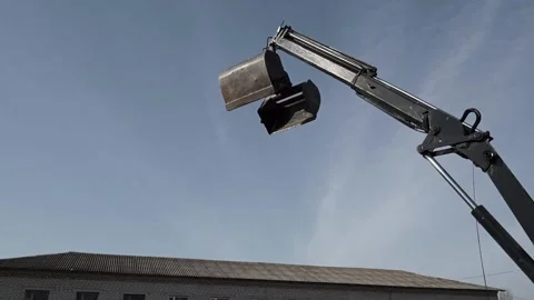 Black construction loading crane with empty bucket moves Stock Footage 200869442