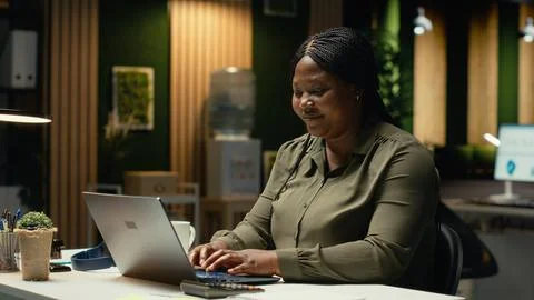 Black consultant focusing on a complex problem in a dark office at midnight Stock Photos