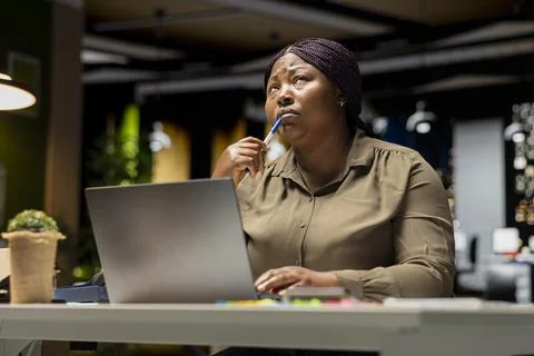Black consultant focusing on a complex problem in a dark office at midnight Stock Photos