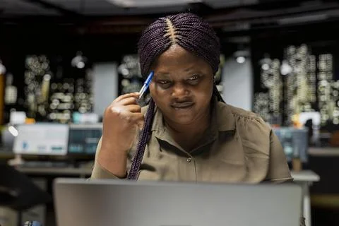 Black consultant focusing on a complex problem in a dark office at midnight Stock Photos