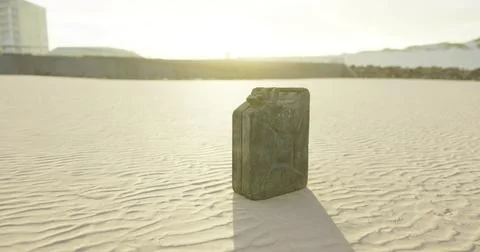 Black container on sandy beach during sunrise with soft light reflections Stock Illustration