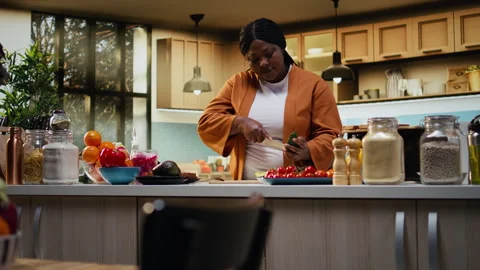Black content creator cutting avocado in food video at the counter Stock Footage 333609661