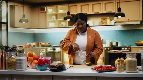 Black content creator, slicing avocado, cooking process, home chef Stock Footage 333609821