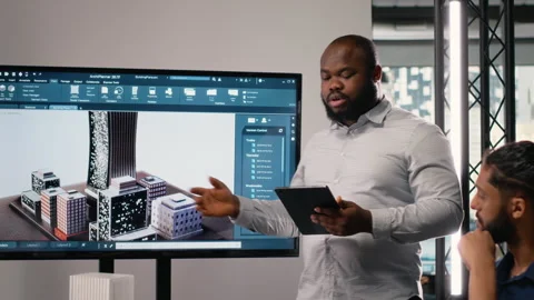 Black contractor reviewing architectural software and 3D models with his team Stock Footage 316652985