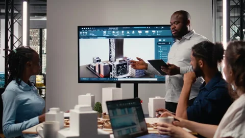 Black contractor reviewing architectural software and 3D models with his team Stock Footage 316795516