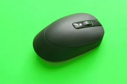 Black Cordless Computer Mouse on Green Background Foto stock