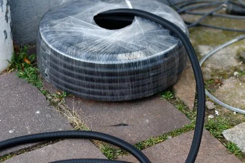 Black corrugated plastic pipe roll for construction Stock Photos