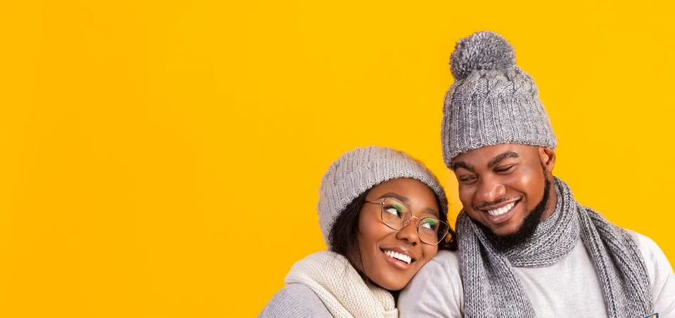 Black couple in love cuddling over yellow background Stock Photos