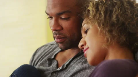 Black couple sitting on couch smiling Stock-Footage 41482346
