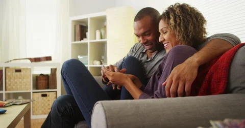 Black couple using smartphone together on couch Stock-Footage 44498183