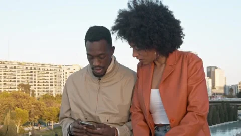 Black couple using smartphone together outdoors Stock Footage 339852400