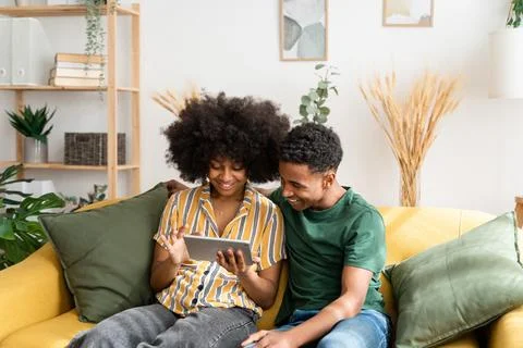 Black couple using tablet on sofa Stock Photos