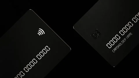 Black credit cards rotating elegantly on a dark background, showcasing the sleek Stock Footage 291961013