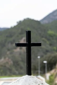 A black cross is on a hillside Foto stock
