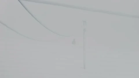 Black crow flying off from a rooftop on a misty snowy day Stock-Footage 262044982