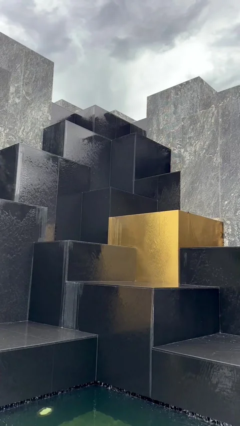 Black Cube Waterfall Art Installation with One Golden Cube Vertical Video Stock Footage 282533735