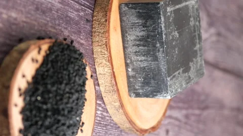 Black cumin seeds and bar soap on wooden rustic surface slow motion. Video stock 331900404