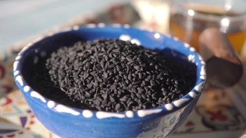 Black cumin seeds and oils on a table Stock-Footage 343657633