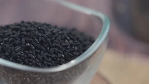 Black cumin seeds pile in clear bowl macro shot with shallow depth of field.. Video stock 332108740