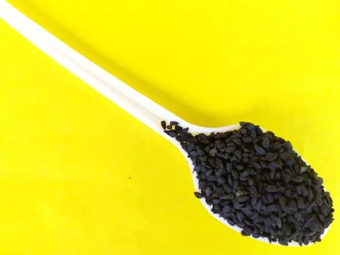 Black cumin seeds in a spoon. Stock Photos
