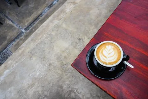 Black cup of coffee on the table corner, high angle view Stock Photos