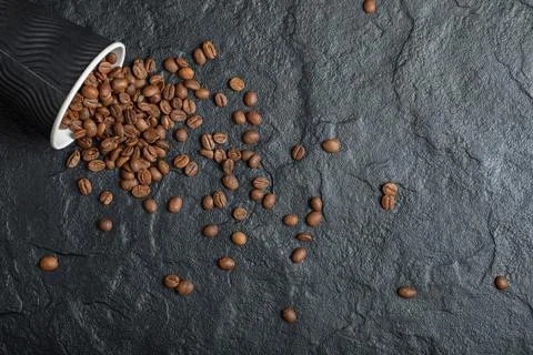 A black cup full of coffee beans on a dark background Stock Photos