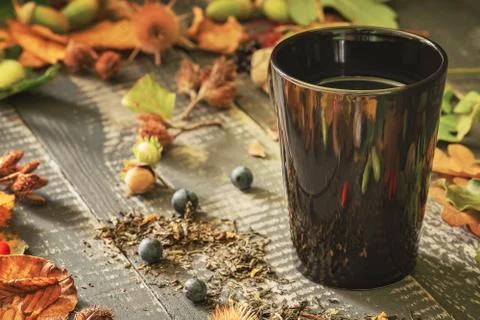 Black cup with tea on old weathered wooden table Stock Photos