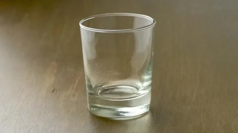 Black-currant fruit beverage pouring into clear drinking cup upon rustic wood Video stock 62223711