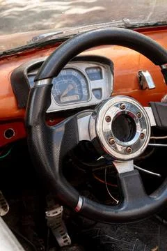 Black custom steering wheel with chrome center sits in front of retro speedom Stock-Fotos