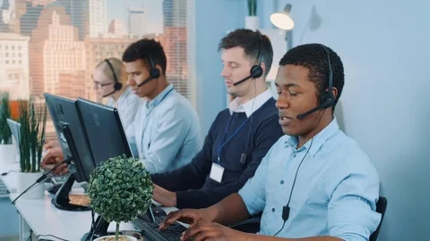 Black customer support agent working in busy call center by talking to the Stock Footage 124252688