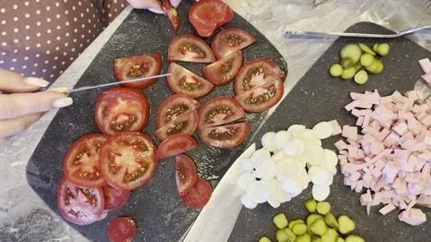 A black cutting board with a knife on it and a pile of tomatoes Stock Footage 279299435
