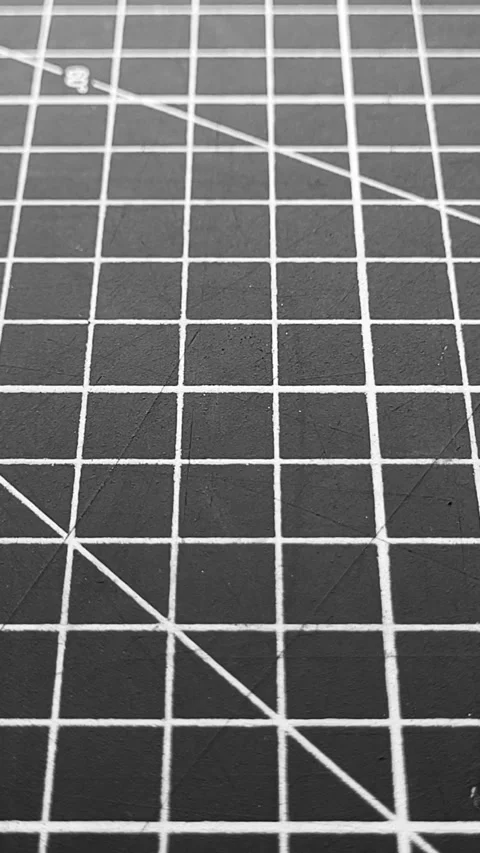 Black cutting mat with a white grid, close up. Dolly-out shot. Stock Footage 287082638