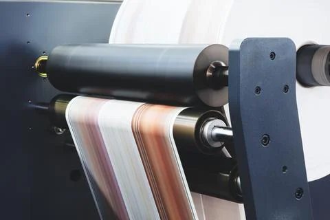 Black cylindrical rollers move paper through printing press. White paper feed Stock Photos