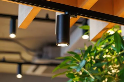Black cylindrical track light emits soft glow Stock Photos