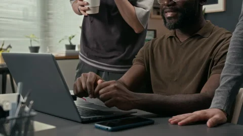 Black Data Analyst Pointing at Laptop Screen Speaking with Two Unknown Coworkers Stock Footage 329610770