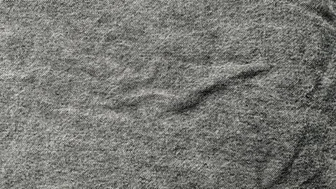 Black denim fabric texture creates organic creases in a minimalist monochrome Stock-Fotos