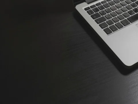 Black desk with silver laptop and phone Video stock 80538044