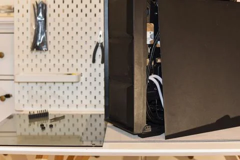 Black desktop computer tower open side panel reveals internal components on desk Foto stock
