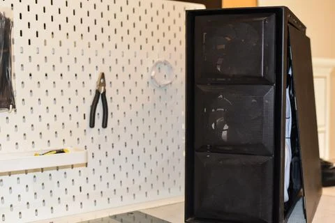 Black desktop computer tower with open side panel internal components next Foto stock