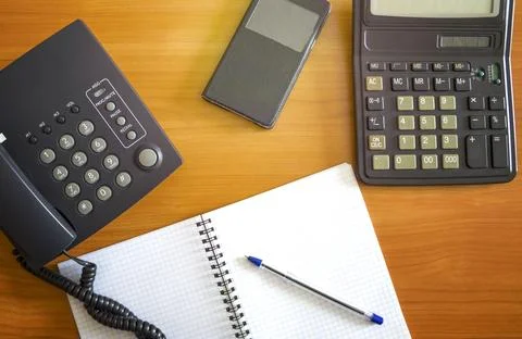 The black desktop push-button telephone on desk in office. Black phone with.. Stock Photos